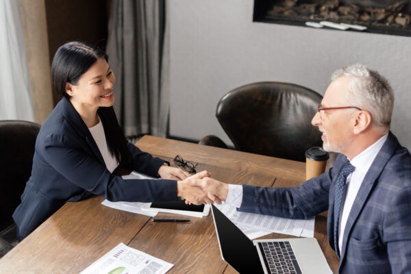 Entry-level sales professional shaking hands with a client